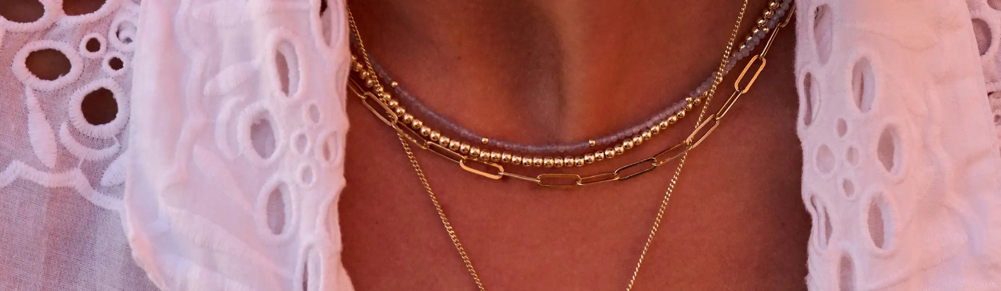 Een gelaagde gouden kettinghalsketting met een mix van kralen-, schakel- en delicate kettingontwerpen.