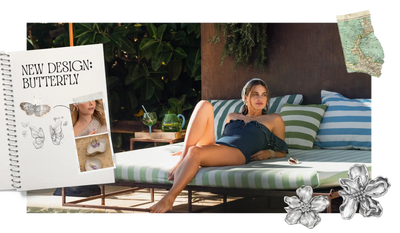 Een vrouw ligt lui op een gestreept buitenbed in een elegante marineblauwe badpak met geruite details.