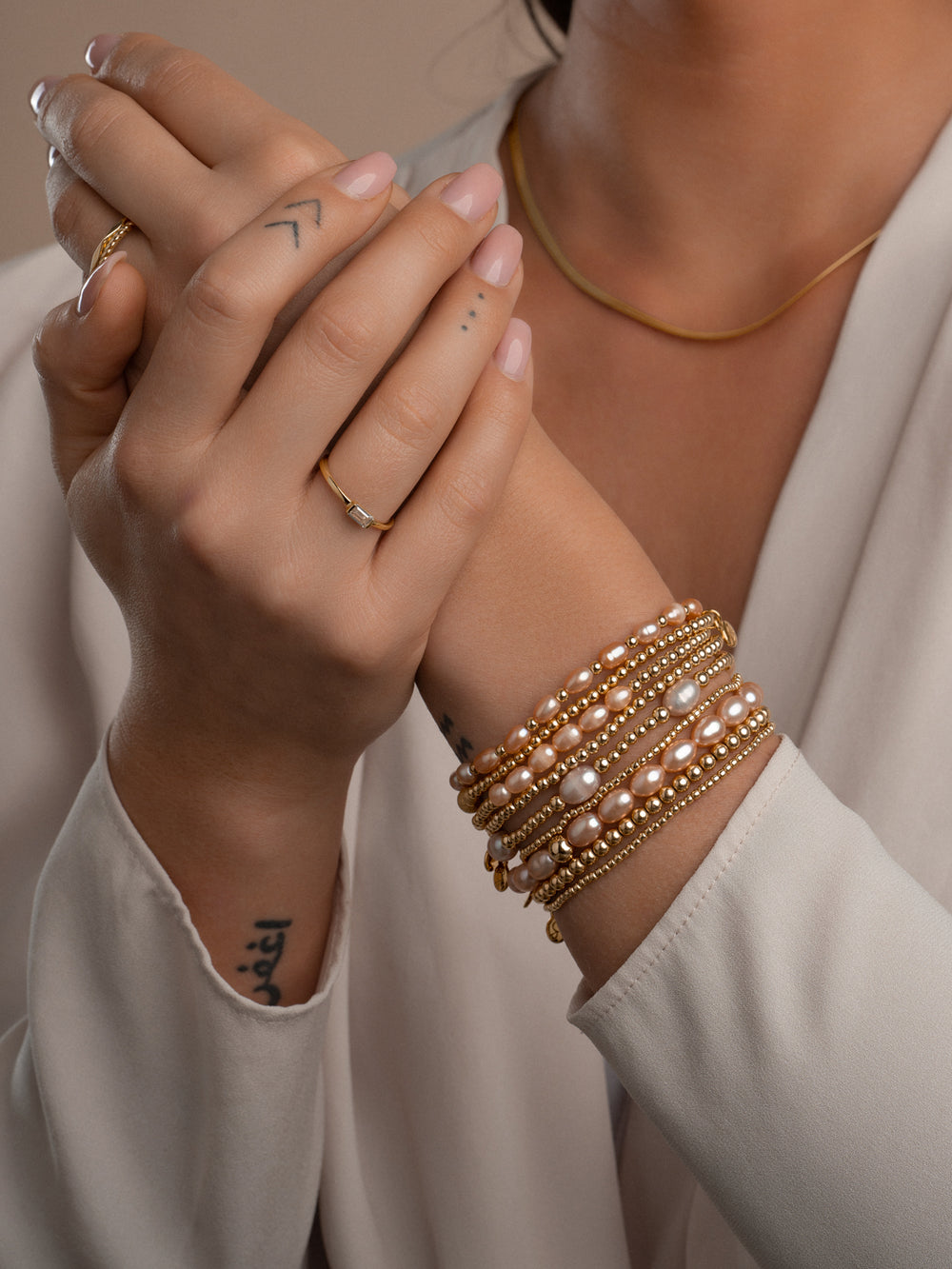 Dames armband met echte peachkleurige parels en goudkleurige accenten #kleur_goud