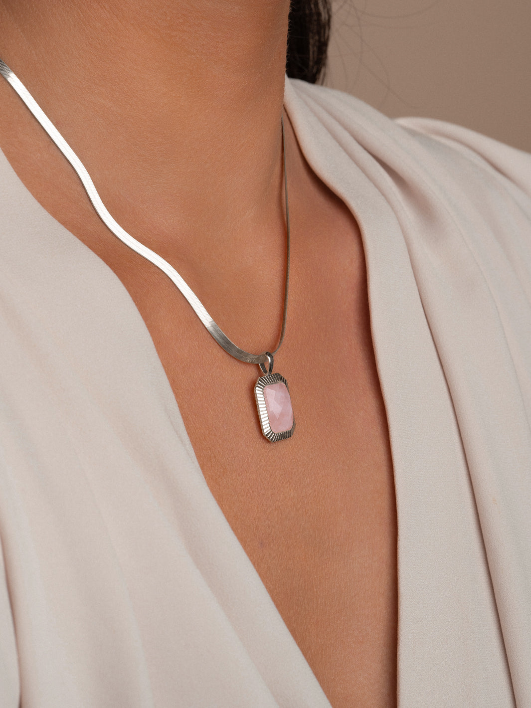 goudkleurig collier met roze edelsteenhanger 