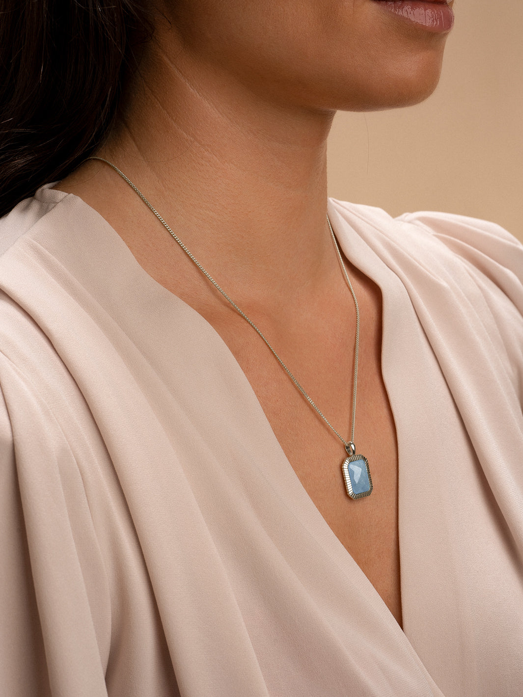 Vrouw met zilveren baguette pendant blue lace agate edelsteen aan gourmette-ketting 