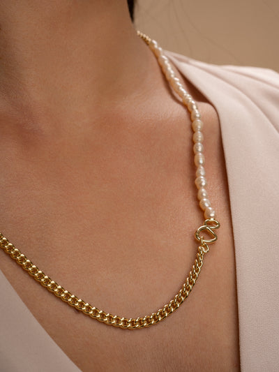 Close up foto van model met de link ketting en armband samen gedragen in goud met parel