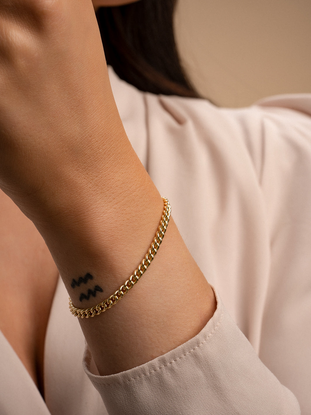 Model draagt de curb chain armband in het goud