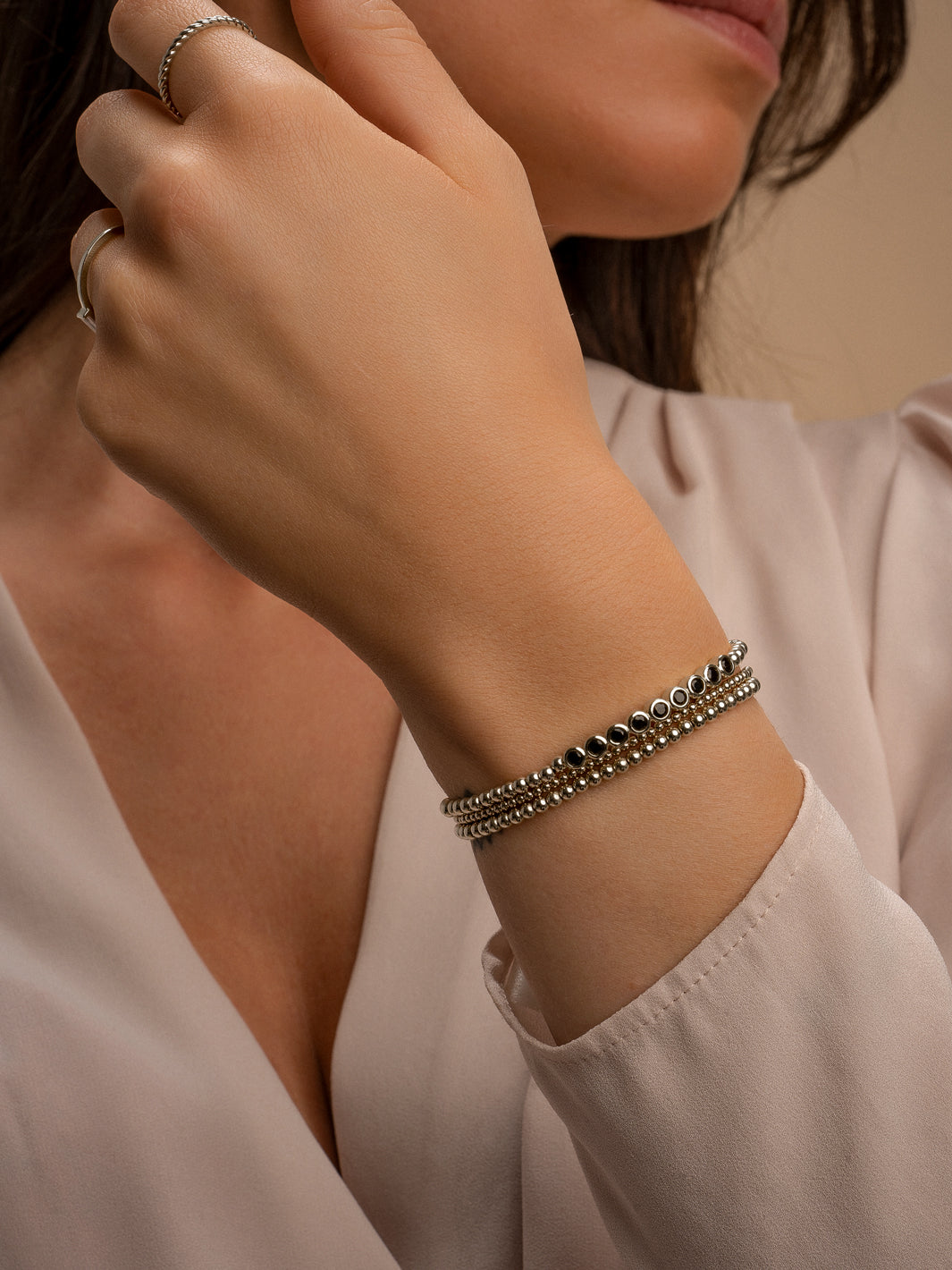Vrouwen pols met zilveren kralen armbanden en hand met zilveren Sparkling Jewels ringen