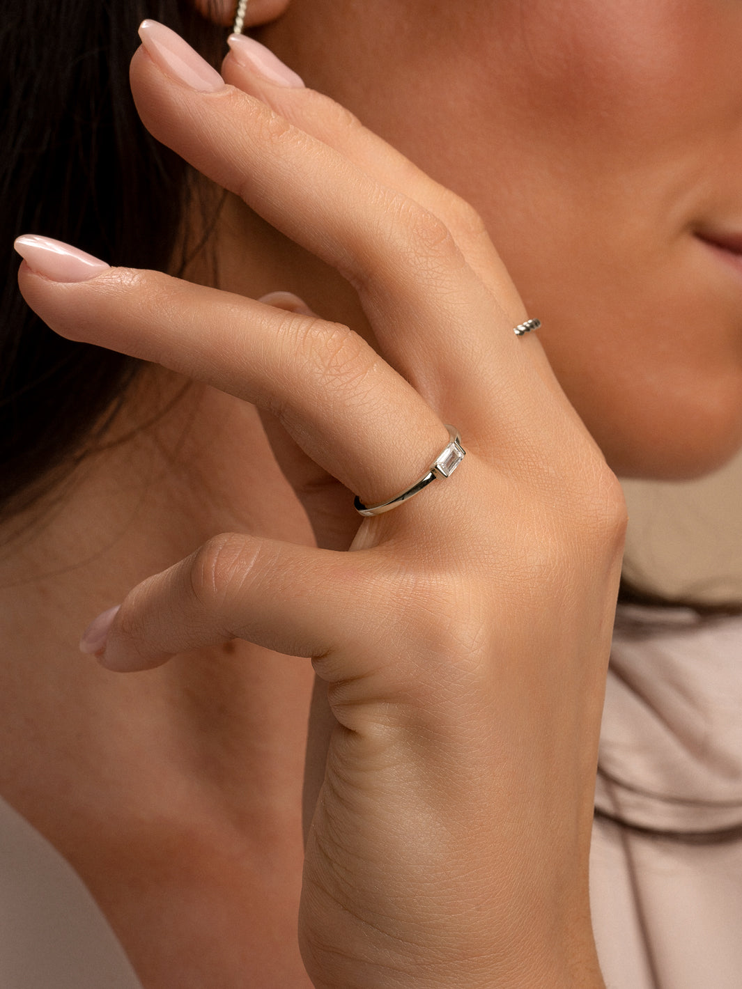 Hand met zilveren ring baguette met transparant CZ steen